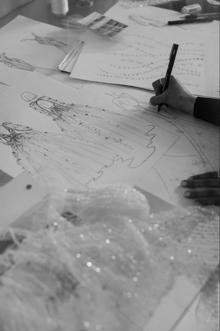 Evening dress sketches and fabric on a design table